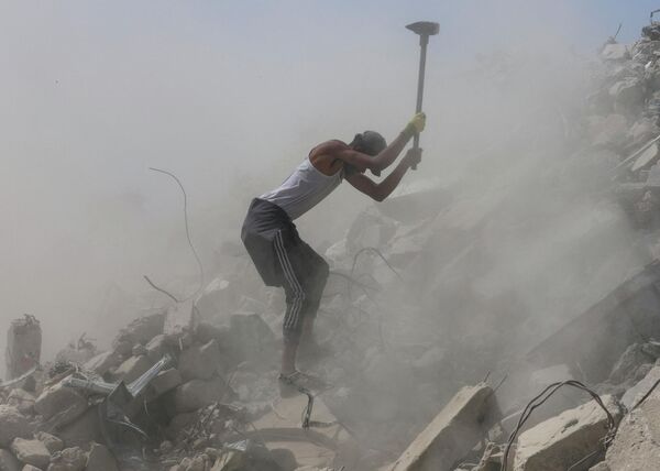 Un trabajador palestino retira escombros en una de las localidades en el sur de la Franja de Gaza. - Sputnik Mundo