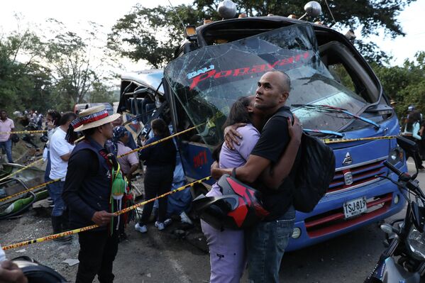 Los familiares de las víctimas fallecidas en la explosión en un autobús se abrazan frente al vehículo destrozado, Colombia. - Sputnik Mundo
