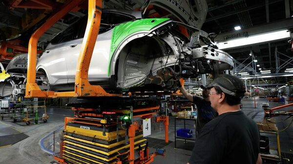 Trabajadores de la línea de montaje instalan una batería LG en un Chevrolet Bolt EV 2023 en la planta de ensamblaje Orion de General Motors, el 15 de junio de 2023  - Sputnik Mundo