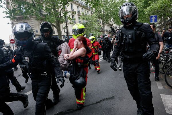 Policías evacúan a una mujer herida durante la marcha sindical del Primero de Mayo en París, Francia. - Sputnik Mundo
