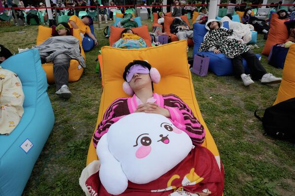 Los participantes toman una siesta durante el Concurso Hangang 2026 en el Parque Yeouido Hangang en Seúl, Corea del Sur. - Sputnik Mundo