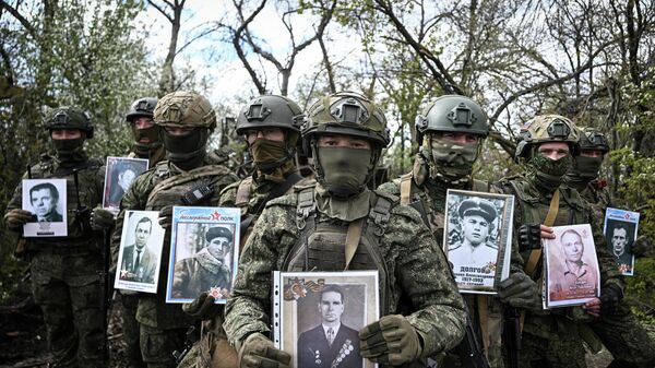 Военнослужащие расчета САУ 2С7 Пион 34-й артиллерийской дивизии 273-й артиллерийской бригады группировки войск Запад приняли участие в акции Бессмертный полк в зоне СВО  - Sputnik Mundo