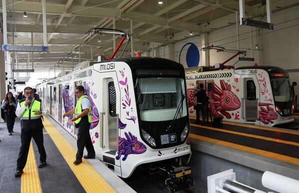 La mascota local se unirá a las figuras oficiales del torneo: Zayu (México), Maple (Canadá) y Clutch (Estados Unidos), pero será un personaje exclusivo de la Ciudad de México.En la foto: trabajadores de la línea del metro ligero siguen en pie, mientras el Gobierno de la Ciudad de México da a conocer la línea de metro ligero renovada. - Sputnik Mundo