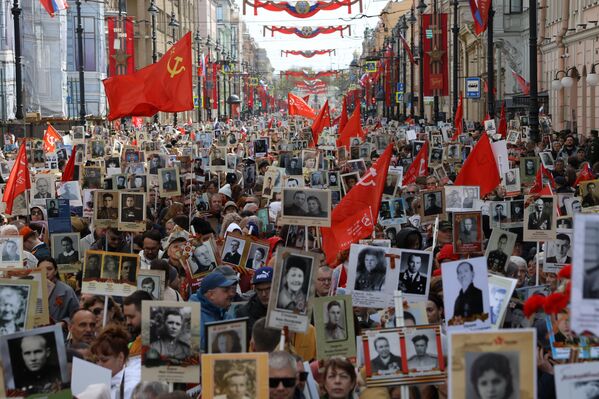 Los participantes en la marcha del Regimiento Inmortal —dedicada al 81.º aniversario de la Victoria en la Gran Guerra Patria— desfilan por la ciudad rusa de San Petersburgo. - Sputnik Mundo