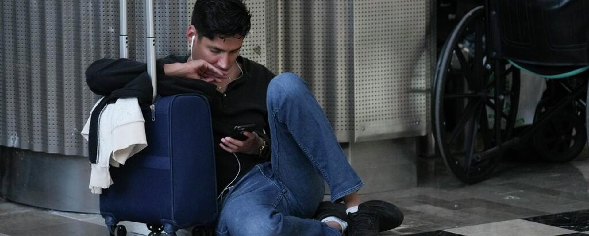 Un pasajero observa su teléfono inteligente mientras espera en el Aeropuerto Internacional Benito Juárez de la Ciudad de México (archivo) - Sputnik Mundo, 1920, 17.05.2026