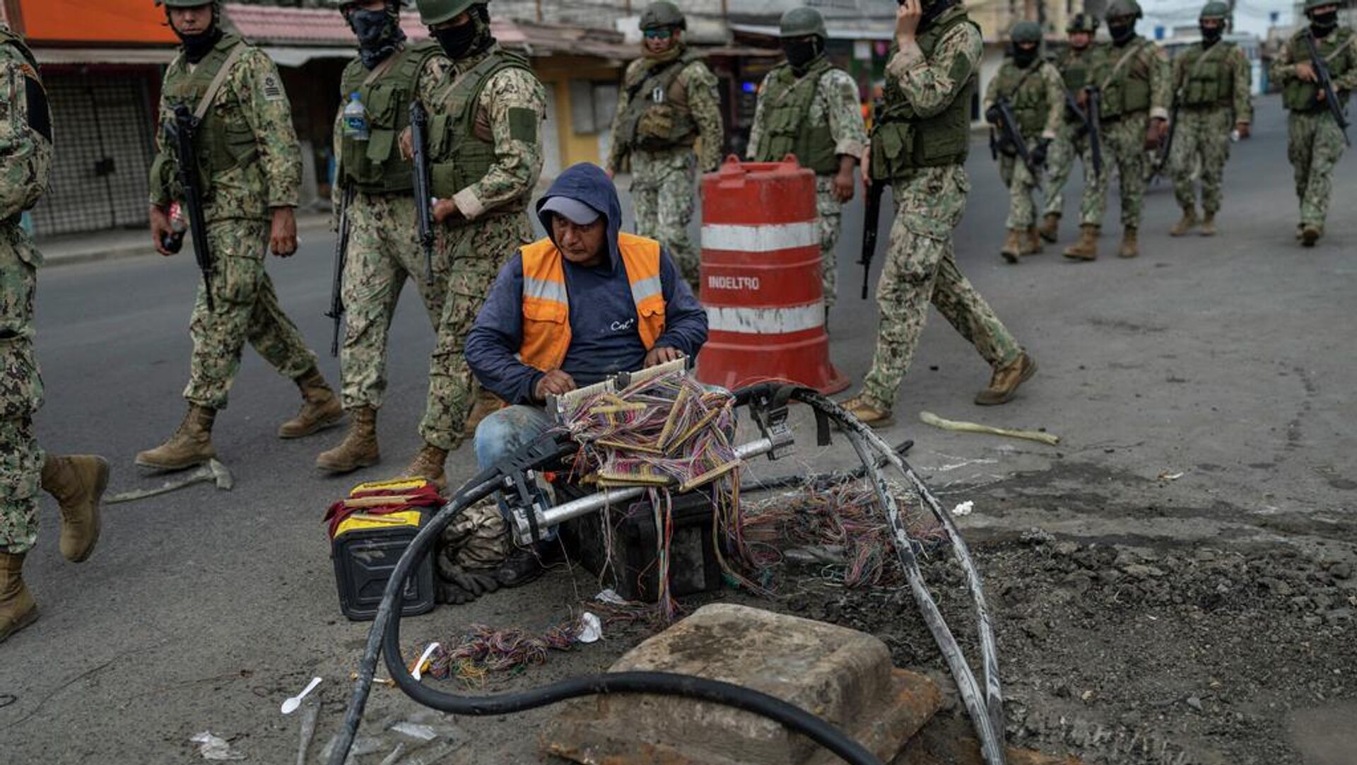 Un trabajador repara cables mientras soldados patrullan Durán, ciudad hermana de Guayaquil, Ecuador. Un trabajador repara cables mientras soldados patrullan Durán, ciudad hermana de Guayaquil, Ecuador. - Sputnik Mundo, 1920, 19.05.2026