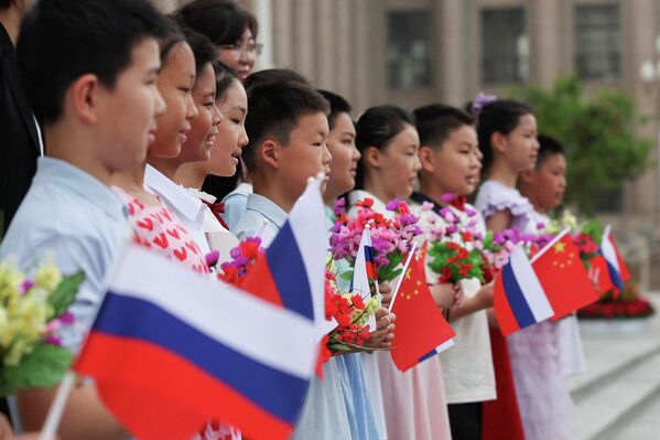 Muchos niños llevaban banderas y flores de Rusia y China. - Sputnik Mundo