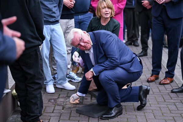 El presidente de Alemania, Frank-Walter Steinmeier, limpia las Stolpersteine (piedras de tropiezo) en memoria de las víctimas del Holocausto en Dorsten, Alemania.  - Sputnik Mundo