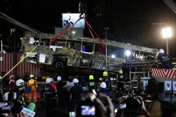 Una grúa retira el autobús que chocó contra un tren y varios vehículos en la capital tailandesa, Bangkok. Como consecuencia del accidente, varias personas perdieron la vida y decenas resultaron heridas. - Sputnik Mundo