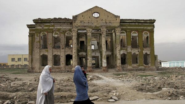 Mujeres afganas caminan junto a un edificio que fue destruido, Kabul, Afganistán, 2008 - Sputnik Mundo