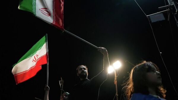 Manifestantes ondean banderas iraníes durante una concentración a favor del gobierno en Teherán - Sputnik Mundo