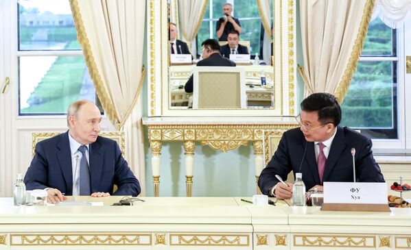 El presidente ruso, Vladímir Putin, durante una reunión con directores de agencias de información internacionales en el Palacio Konstantínovski, en el marco del SPIEF, Rusia.A su derecha: el director general de la agencia china Xinhua, Fu Hua. - Sputnik Mundo