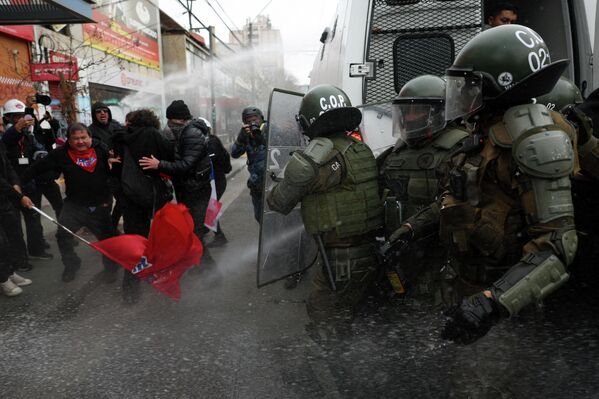 Manifestantes y policías antidisturbios se enfrentan durante una protesta en el día en que el presidente de Chile, José Antonio Kast, pronuncia su primer discurso del Estado de la Nación en el Congreso Nacional, en Valparaíso, Chile. - Sputnik Mundo
