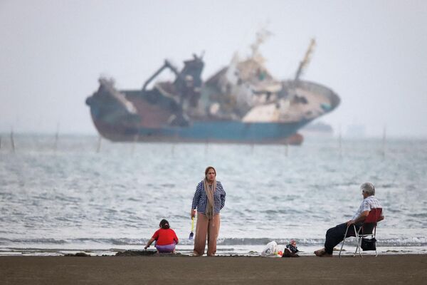Las personas se reúnen en una playa desde donde se divisa una embarcación en el estrecho de Ormuz, cerca de la costa de Bandar Abbás, Irán. - Sputnik Mundo