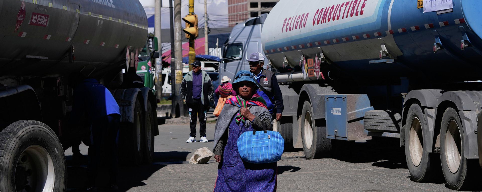 Una mujer pasa junto a unos camiones cisterna que bloquean una carretera durante una huelga provocada por la escasez de gasóleo en El Alto, Bolivia - Sputnik Mundo, 1920, 19.09.2026