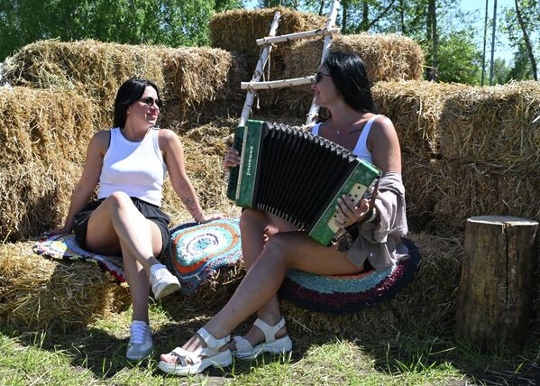 Unas visitantes descansan en un pajar improvisado durante el festival de cultura rusa Mi patria es Rusia, celebrado en la ciudad de Krasnoyarsk. - Sputnik Mundo