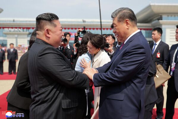 El presidente chino, Xi Jinping, saluda al líder norcoreano, Kim Jong-un, durante su visita de Estado a Pionyang, Corea del Norte. - Sputnik Mundo