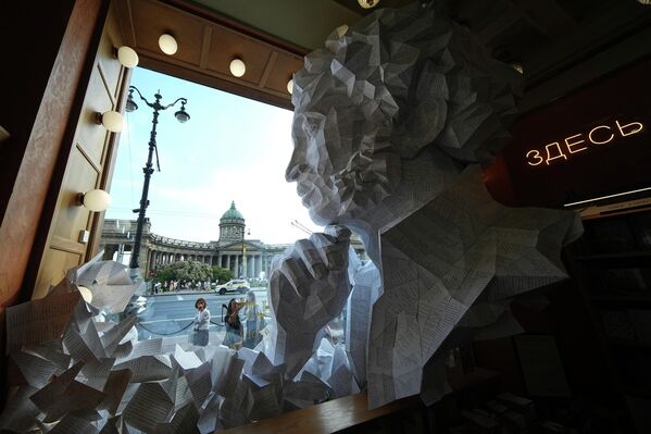 Las personas contemplan una gran escultura de papel del poeta ruso Alexandr Pushkin expuesta en el escaparate de una librería de San Petersburgo, Rusia. - Sputnik Mundo