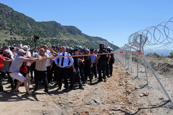 Los manifestantes intentan derribar una valla de un sitio en construcción durante una protesta contra los planes de construir un complejo turístico en la zona de Rrjoll, norte de Albania. - Sputnik Mundo
