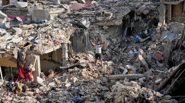 Un hombre que regresa a su aldea tras el anuncio de un acuerdo inicial de alto el fuego entre EEUU e Irán muestra la señal de la victoria mientras se encuentra sobre los escombros de su casa destruida en la localidad de Nabatiye, en el sur de Líbano. - Sputnik Mundo