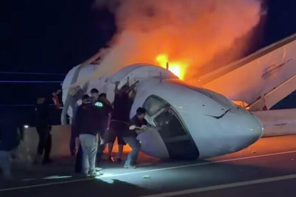 Personas intentan sacar a los pasajeros de un avión después de que este se estrellara en una autopista en Laredo, Texas. - Sputnik Mundo