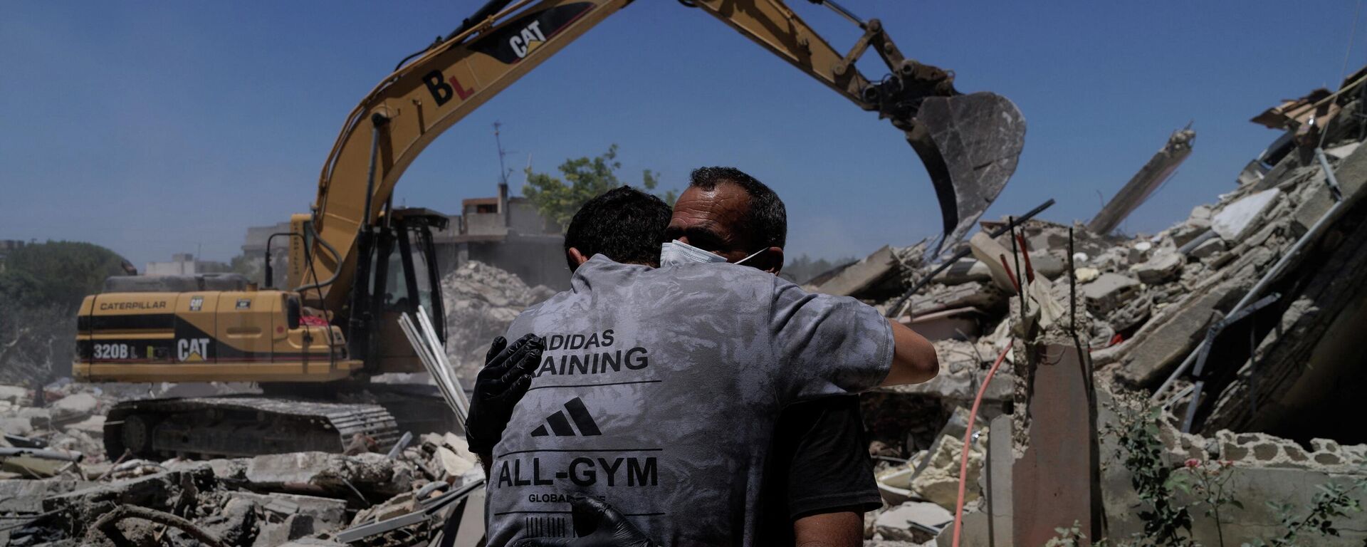 Rescatistas se abrazan mientras trabajan en el lugar de un ataque aéreo israelí en Barish, distrito de Tiro, el Líbano, 20 de junio de 2026 - Sputnik Mundo, 1920, 20.06.2026