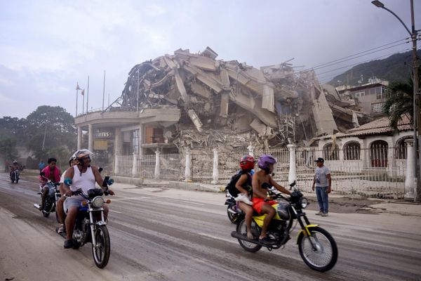 Personas pasan junto a un edificio destruido en el estado venezolano de La Guaira por el terremoto que sacudió al país sudamericano el 24 de junio. - Sputnik Mundo