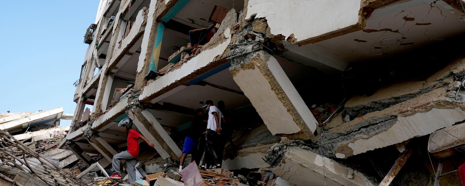 Los vecinos caminan entre los escombros dos días después de que los terremotos azotaran Catia La Mar, en Venezuela - Sputnik Mundo, 1920, 27.06.2026