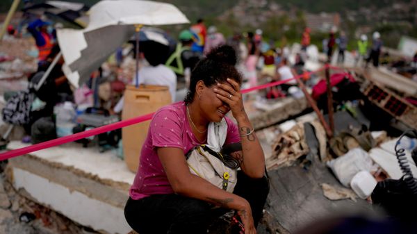 Una mujer llora mientras rescatistas buscan sobrevivientes en un edificio que se derrumbó durante los terremotos en Venezuela  - Sputnik Mundo