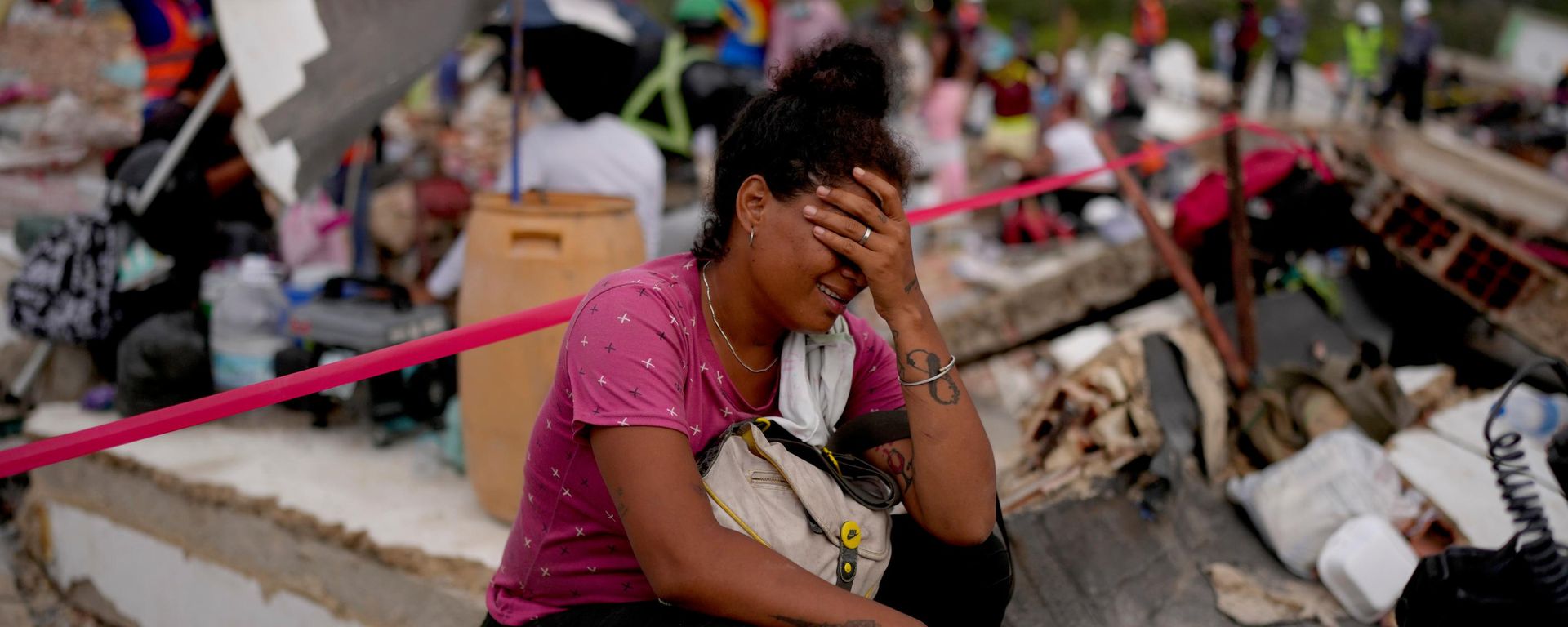 Una mujer llora mientras rescatistas buscan sobrevivientes en un edificio que se derrumbó durante los terremotos en Venezuela  - Sputnik Mundo, 1920, 01.07.2026
