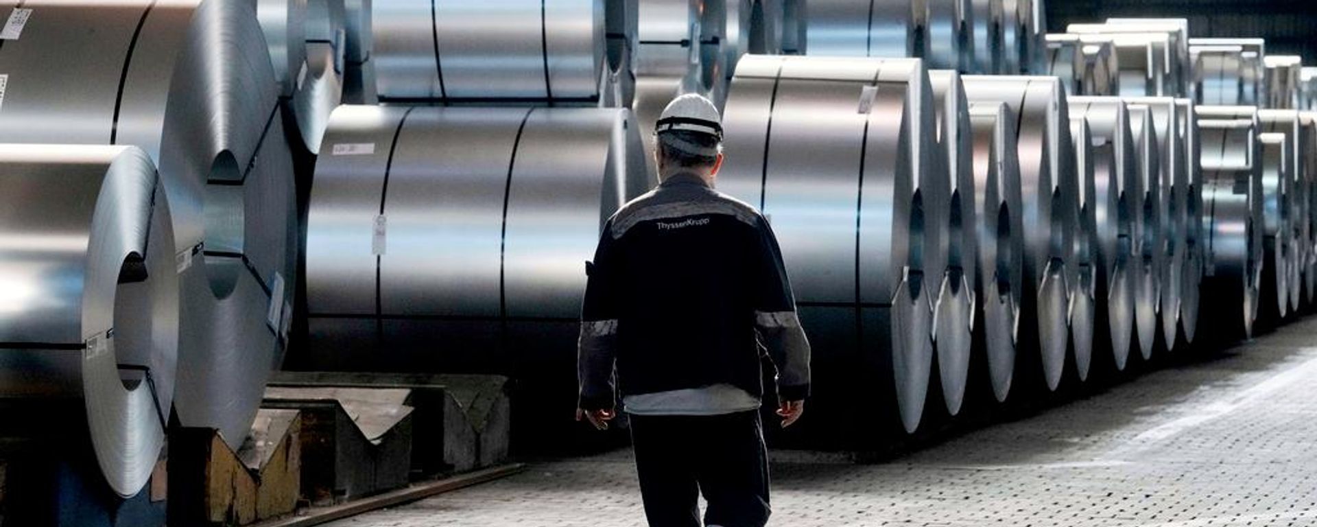 Un trabajador siderúrgico camina junto a bobinas de acero en la acería Thyssenkrupp en Duisburgo, Alemania - Sputnik Mundo, 1920, 06.07.2026