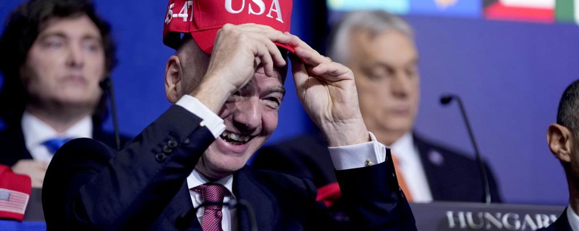 Giovanni Infantino, presidente de la FIFA, se prueba una gorra de EEUU.durante una reunión de la Junta de la Paz celebrada en el Instituto Estadounidense de la Paz, el 19 de febrero de 2026, en Washington. - Sputnik Mundo, 1920, 09.07.2026