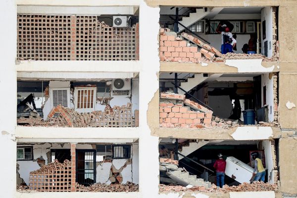 Personas trasladan sus pertenencias al interior de un edificio gravemente dañado tras el doble terremoto en Venezuela. - Sputnik Mundo