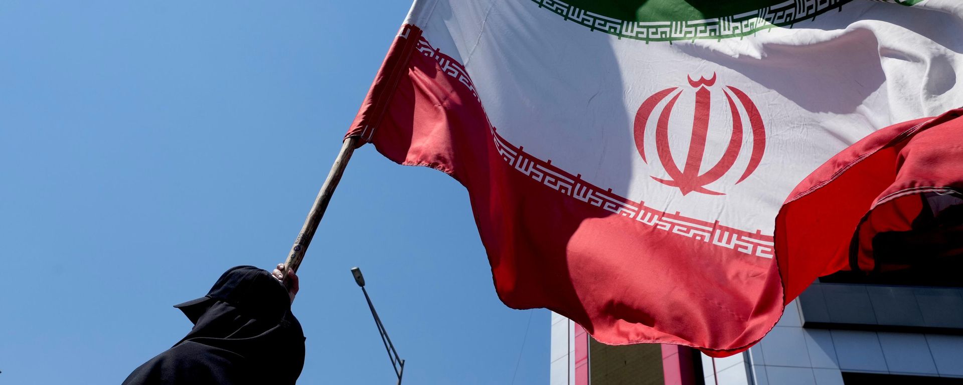 Una mujer sostiene una bandera iraní - Sputnik Mundo, 1920, 11.07.2026