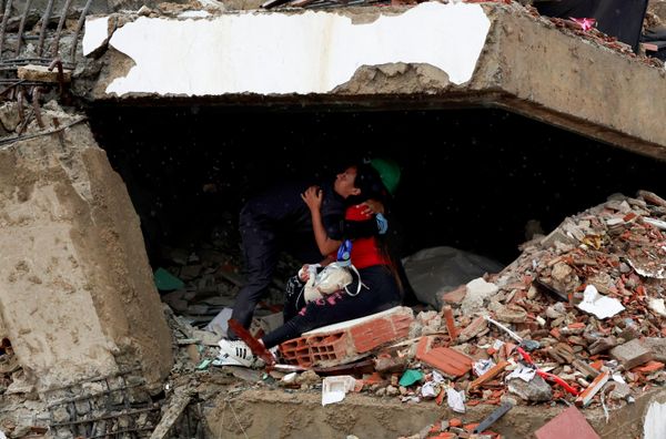 Un abrazo en medio de los escombros de un edificio tras el doble sismo que sacudió Venezuela. - Sputnik Mundo