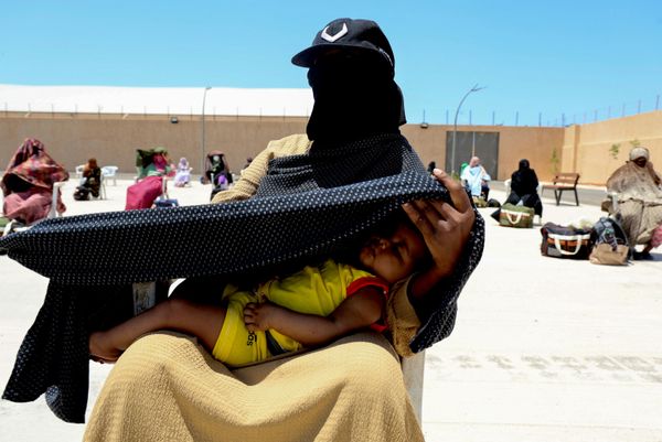 Una mujer somalí migrante sostiene un niño durante el proceso de deportación a su país en Libia. - Sputnik Mundo