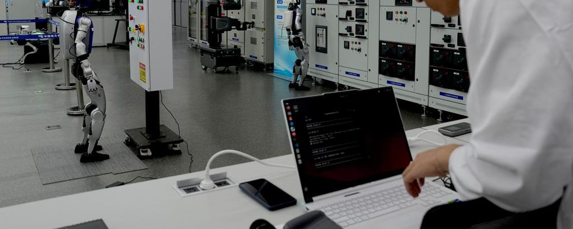 Un empleado utiliza un ordenador portátil mientras robots de IA demuestran su funcionamiento en el centro de control de la red eléctrica Un empleado utiliza un ordenador portátil mientras robots de IA demuestran su funcionamiento en el centro de control de la red eléctrica - Sputnik Mundo, 1920, 19.07.2026