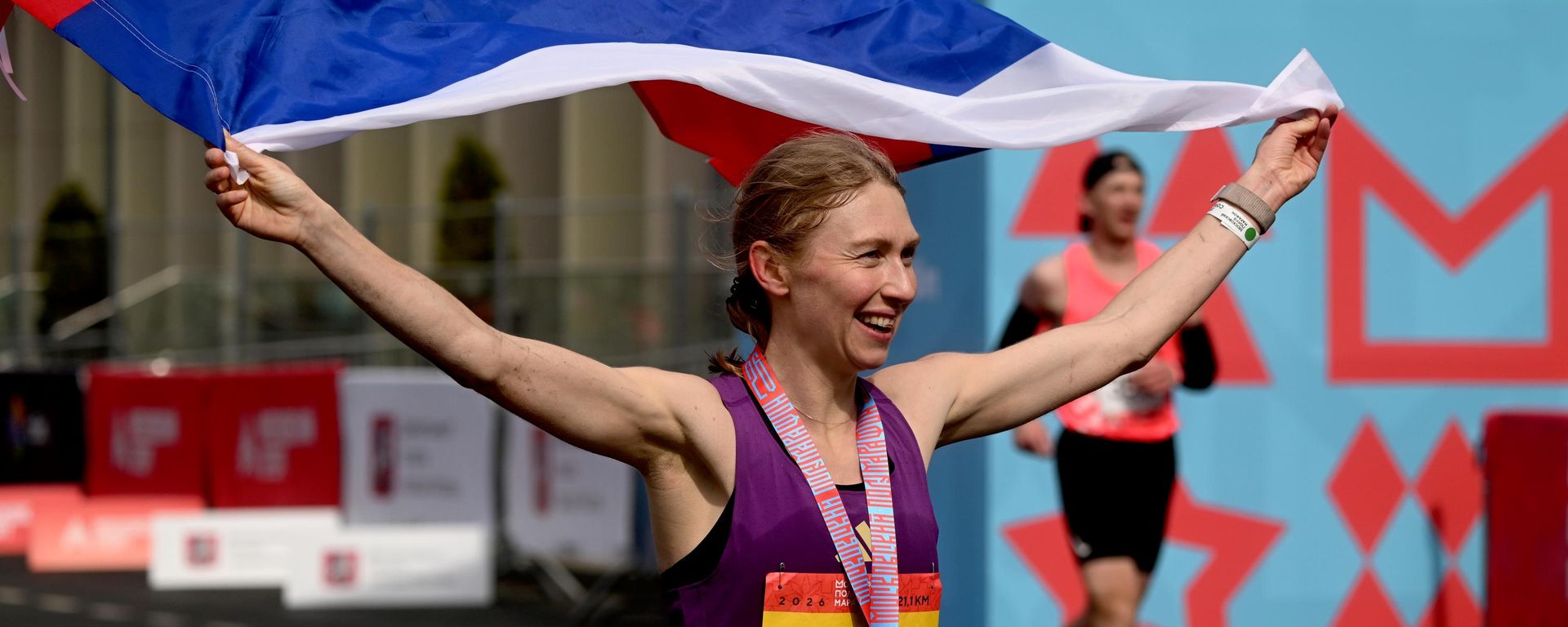 Una atleta rusa tras cruzar la meta en la carrera de 21,1 km de la media maratón de Moscú - Sputnik Mundo, 1920, 23.07.2026
