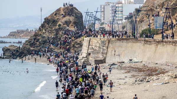 Varias personas caminan por una playa tras intentar cruzar desde la ciudad marroquí de Castillejos al enclave español de Ceuta - Sputnik Mundo
