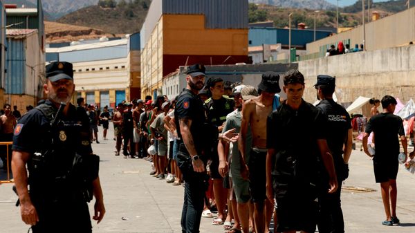 Migrantes hacen cola para recibir alimentos básicos de la ONG local Media Luna Blanca en medio de los recientes cruces masivos de migrantes a pie y por mar desde Marruecos al territorio español, en Ceuta, España, 6 de agosto de 2026  - Sputnik Mundo