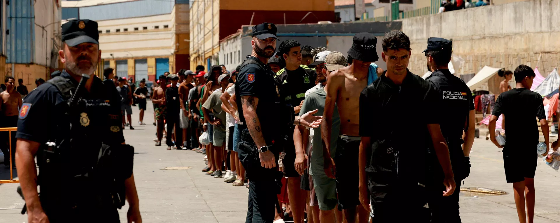 Migrantes hacen cola para recibir alimentos básicos de la ONG local Media Luna Blanca en medio de los recientes cruces masivos de migrantes a pie y por mar desde Marruecos al territorio español, en Ceuta, España, 6 de agosto de 2026 Migrantes hacen cola para recibir alimentos básicos de la ONG local Media Luna Blanca en medio de los recientes cruces masivos de migrantes a pie y por mar desde Marruecos al territorio español, en Ceuta, España, 6 de agosto de 2026 - Sputnik Mundo, 1920, 09.08.2026