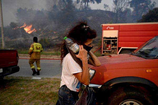 Una mujer se cubre el rostro para protegerse del humo durante un incendio forestal en Siviri, en la península de Calcídica, el norte de Grecia. - Sputnik Mundo