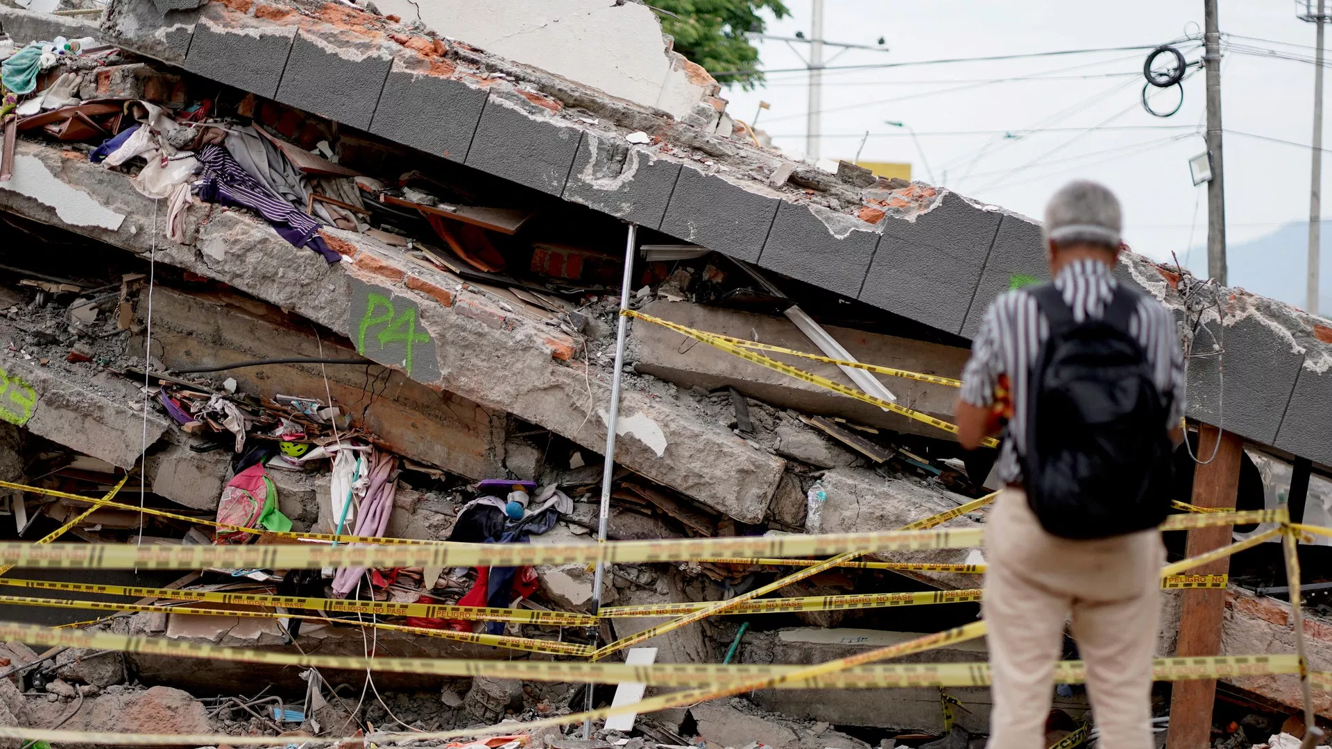 Un hombre permanece de pie junto a los escombros de un edificio derrumbado tras el terremoto de Cali, Colombia, el 14 de agosto de 2026 Un hombre permanece de pie junto a los escombros de un edificio derrumbado tras el terremoto de Cali, Colombia, el 14 de agosto de 2026 - Sputnik Mundo, 1920, 15.08.2026