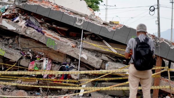 Un hombre permanece de pie junto a los escombros de un edificio derrumbado tras el terremoto de Cali, Colombia, el 14 de agosto de 2026  - Sputnik Mundo
