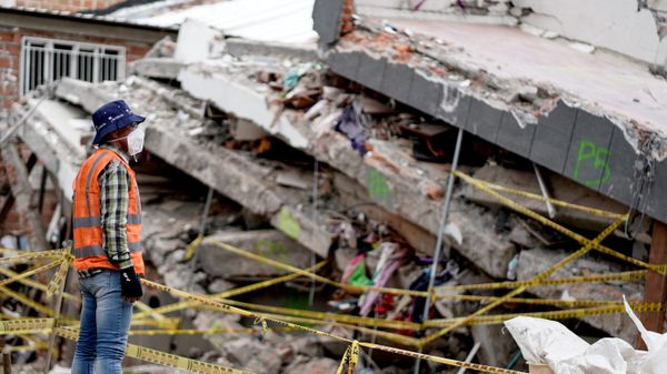 Un rescatista trabaja en el lugar de un edificio derrumbado tras el terremoto en Cali, Colombia, el 14 de agosto de 2026  - Sputnik Mundo