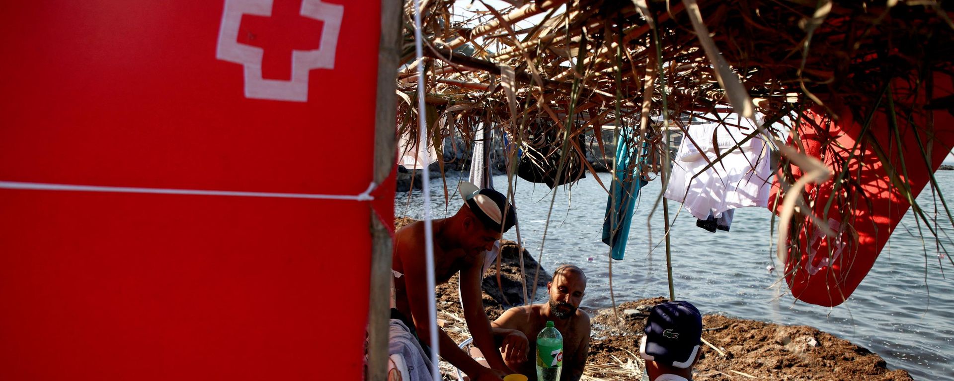Migrantes marroquíes se sientan debajo de un refugio improvisado marcado con una cruz roja en Ceuta - Sputnik Mundo, 1920, 17.08.2026