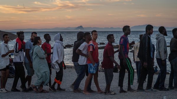 Migrantes que cruzaron de Marruecos a España hacen fila para recibir alimentos en una playa del enclave español de Ceuta, el 3 de agosto de 2026  - Sputnik Mundo