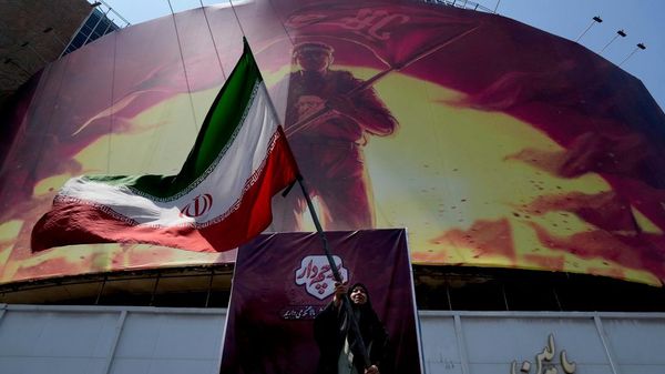 Una mujer ondea una bandera iraní en Teherán  - Sputnik Mundo