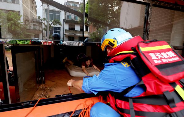 Rescatistas ayudan a una persona que ha quedado atrapada a causa de las inundaciones provocadas por las fuertes lluvias del tifón Narra en China. - Sputnik Mundo