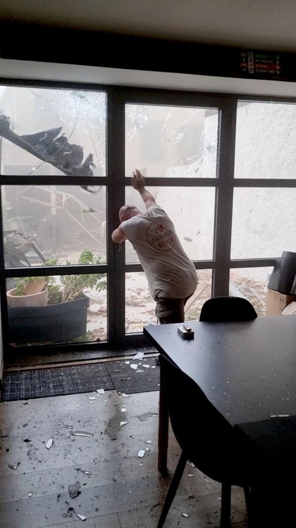 Una persona sostiene la puerta durante un tornado que azota la localidad de Pomas, en Francia. - Sputnik Mundo